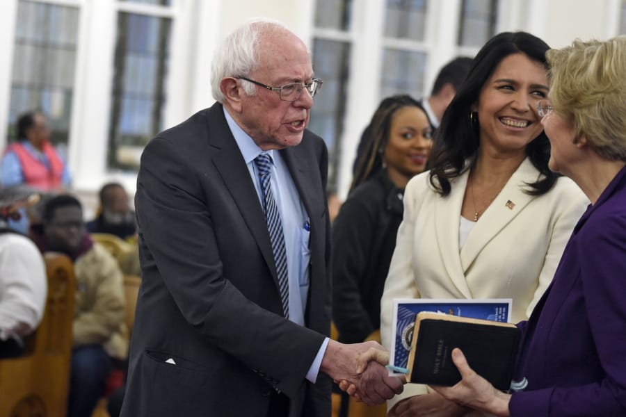 Democratic presidential candidates US. Sen. Bernie Sanders, left, I-Vt. and Sen. Elizabeth Warren, right, D--Mass., shake hands as greets U.S. Rep. Tulsi Gabbard, center, D-Hawaii at a Martin Luther King Jr. Day services at Zion Baptist Church, Monday, Jan. 20, 2020, in Columbia, S.C.