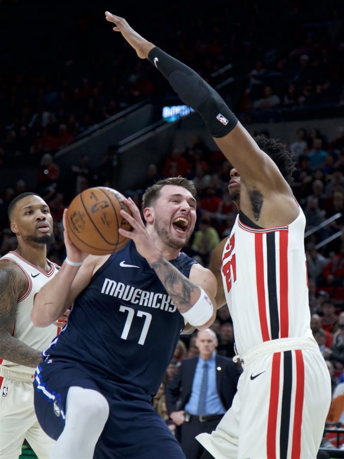 Dallas Mavericks guard Luka Doncic (77) drives to the basket past Portland Trail Blazers center Hassan Whiteside during the first half of an NBA basketball game in Portland, Ore., Thursday, Jan. 23, 2020.
