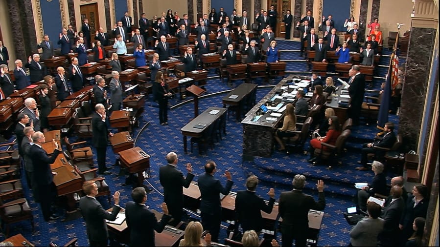 FILE - In this Thursday, Jan. 16, 2020, file image from video, presiding officer Supreme Court Chief Justice John Roberts swears in members of the Senate for the impeachment trial against President Donald Trump at the U.S. Capitol in Washington. Reporters at the Capitol want more cameras in the Senate to cover the impeachment trial and fewer restrictions to talk to senators when they are not sitting in judgment of the president.
