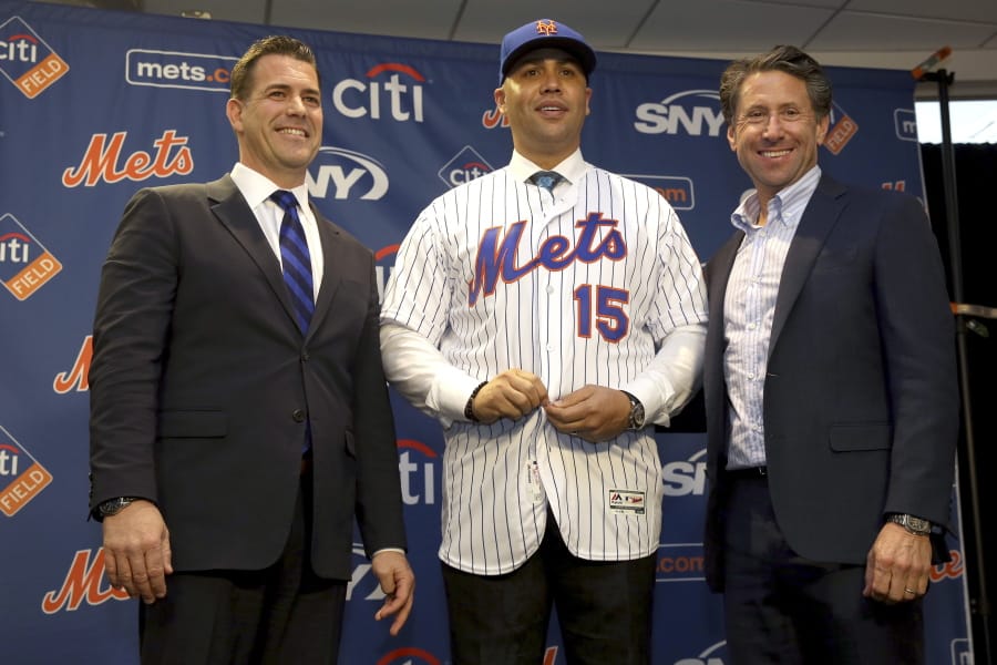 FILE - In this Nov. 4, 2019, file photo, new New York Mets manager, Carlos Beltran, center, poses for a picture with general manager Brodie Van Wagenen, left, and Mets COO Jeff Wilpon during a baseball news conference at Citi Field in New York. Beltran is out as manager of the Mets. The team announced the move Thursday, Jan. 16, 2020.