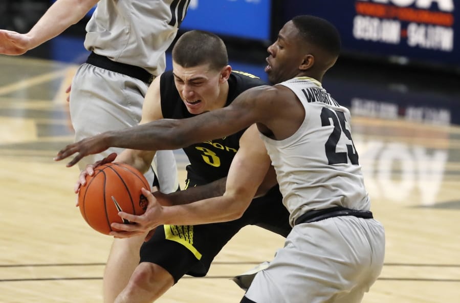 Oregon guard Payton Pritchard, left, fights for control of the ball with Colorado guard McKinley Wright IV in the first half of an NCAA college basketball game Thursday, Jan. 2, 2020, in Boulder, Colo.