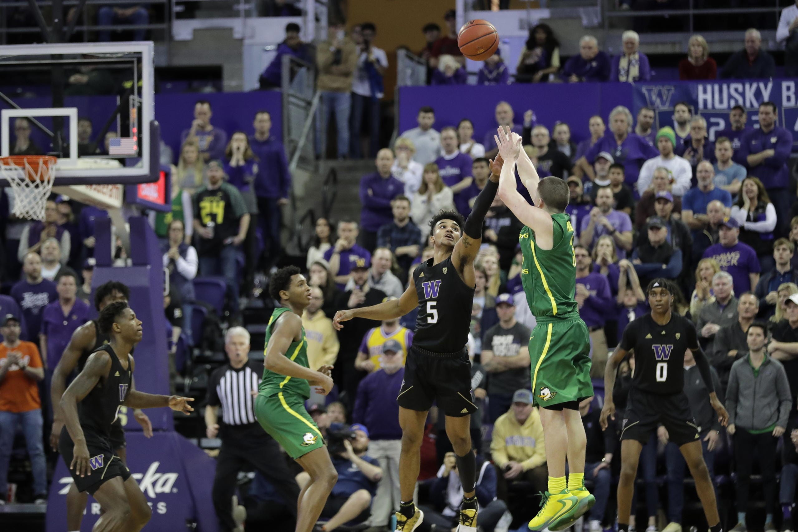 Oregon guard Payton Pritchard, right, shoots the game-winning 3-point basket as Washington guard Jamal Bey (5) tries for the block during overtime in an NCAA college basketball game, Saturday, Jan. 18, 2020, in Seattle. Oregon won 64-61 in overtime. (AP Photo/Ted S.
