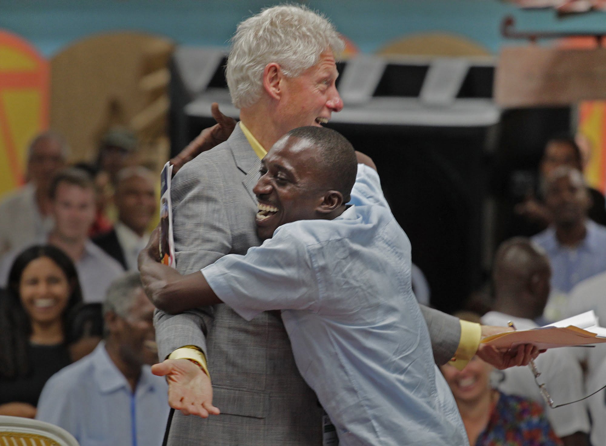 The very thankful Landry Colas, center, gives a big hug to former U.S. president Bill Clinton as he expresses his gratitude at the Caracol Industrial Park opened for business on October 22, 2012, in Caracol, Haiti.