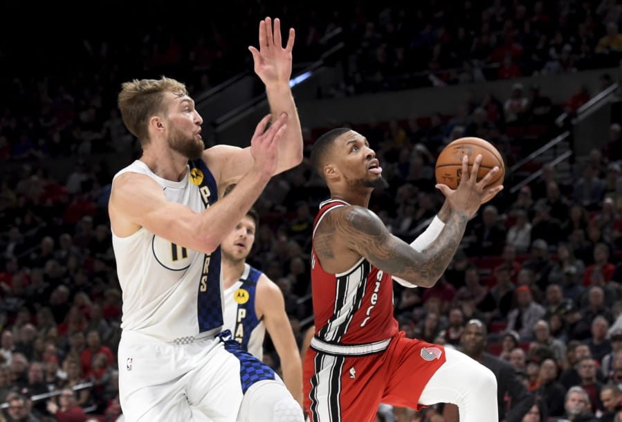 Portland Trail Blazers guard Damian Lillard, right, drives to the basket on Indiana Pacers forward Domantas Sabonis, left, during the second half of an NBA basketball game in Portland, Ore., Sunday, Jan. 26, 2020. Lillard scored 50 points as the Blazers won 139-129.