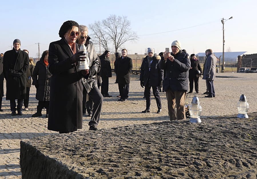 In this image provided by the US Consulate General in Krakow, U.S. House Speaker Nancy Pelosi places a memorial light on the monument to some 1.1 million victims of the World War II Nazi death camp of Auschwitz-Birkenau during a visit to the site of the former camp just days before the 75th anniversary of its 1945 liberation by the Soviet troops, at the Auschwitz-Birkenau Museum, in southern Poland, on Tuesday, Jan. 21, 2020.