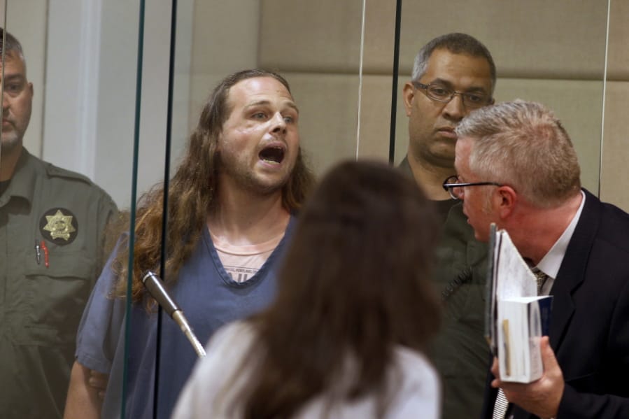 FILE - In this May 30, 2017, fie photo, Jeremy Christian shouts as he is arraigned in Multnomah County Circuit Court in Portland, Ore. Christian, charged with fatally stabbing two men who authorities say confronted him during a racist rant on a Portland, Oregon light-rail train, goes to trial Tuesday, Jan. 21, 2020, two years after the killings that plunged this liberal city into months of soul-searching.