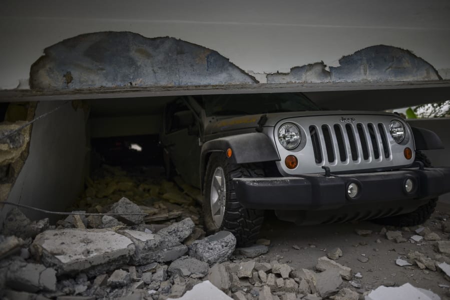 A car is crushed under a home that collapsed after the previous day&#039;s magnitude 6.4 earthquake in Yauco, Puerto Rico, Wednesday, Jan. 8, 2020. More than 250,000 Puerto Ricans remained without water on Wednesday and another half a million without power, which also affected telecommunications.