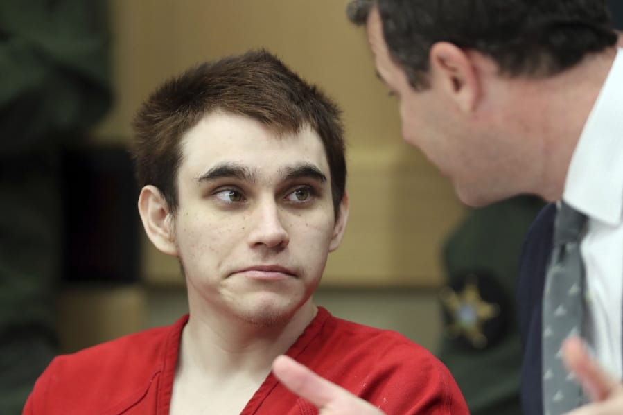 Florida school shooting defendant Nikolas Cruz speaks with one of his defense attorneys, Gabe Ermine, before a hearing at the Broward County Courthouse in Fort Lauderdale, Fla., Wednesday, Jan. 22, 2020.