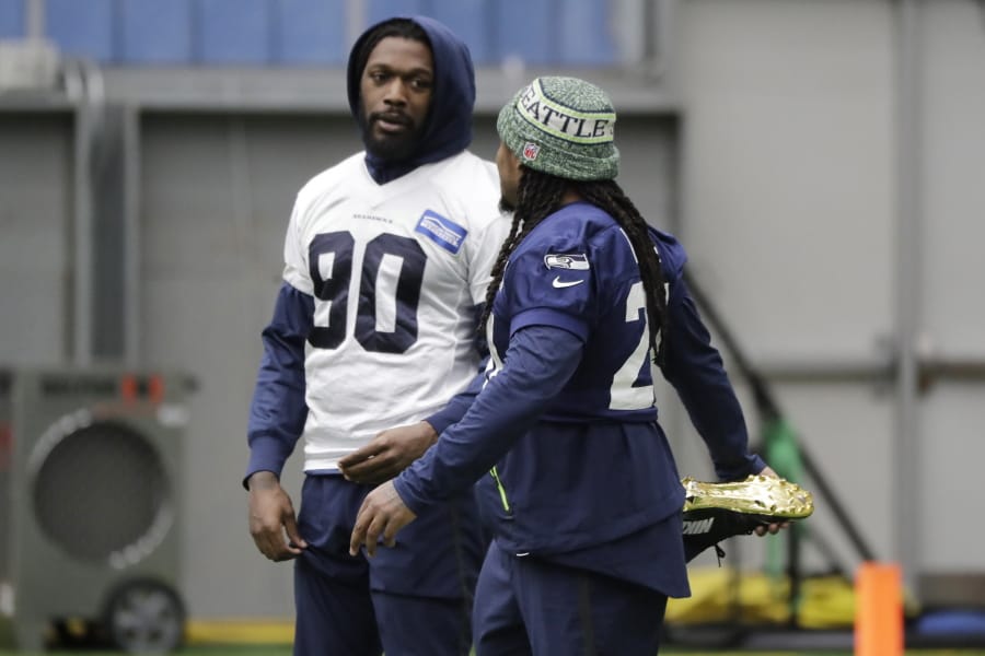 Seattle Seahawks running back Marshawn Lynch, right, stretches as he talks with defensive end Jadeveon Clowney, left, before NFL football practice, Friday, Dec. 27, 2019, in Renton, Wash. (AP Photo/Ted S.