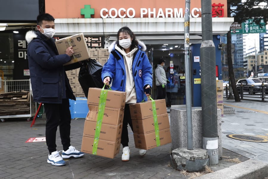 People leave after buying face masks at a pharmacy in Seoul, South Korea, Wednesday, Jan. 29, 2020. Countries began evacuating their citizens Wednesday from the Chinese city hardest-hit by an outbreak of a new virus that has killed 132 people and infected more than 6,000 on the mainland and abroad.