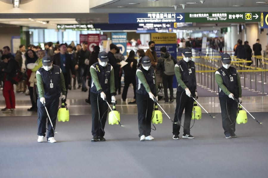 Workers spray antiseptic solution on the arrival lobby amid rising public concerns over the possible spread of a new coronavirus at Incheon International Airport in Incheon, South Korea, Tuesday, Jan. 21, 2020. Heightened precautions were being taken in China and elsewhere Tuesday as governments strove to control the outbreak of a novel coronavirus that threatens to grow during the Lunar New Year travel rush.