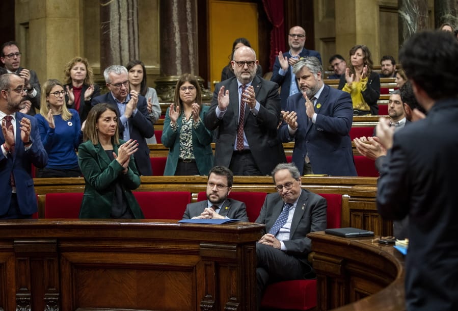 Catalan President Quim Torra, foreground and right, is applauded by members of his party at the Parliament of Catalonia in Barcelona, Spain, Monday, Jan. 27, 2020. The Catalan regional parliament is stripping the president of the prosperous but troubled northeastern region of his lawmaker&#039;s seat because he disobeyed Spain&#039;s strict rules on election propaganda.