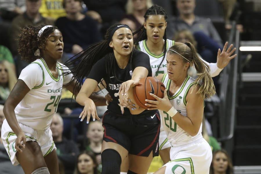 Oregon&#039;s Ruthy Hebard, left, Satou Sabally, rear, and Sabrina Ionescu, right, battle Stanford&#039;s Haley Jones for the ball during Thursday&#039;s game in Eugene, Ore.
