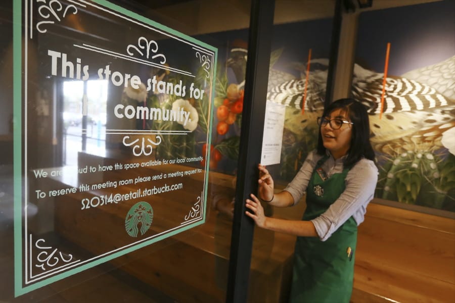 In this Wednesday, Jan. 15, 2020, photo, Belith Ariza, a barista trainer at Starbucks, opens the doors to the community meeting space at a local Starbucks Community Store, in Phoenix. The Seattle-based company plans to open or remodel 85 stores by 2025 in rural and urban communities across the U.S. That will bring to 100 the total number of community stores Starbucks has opened since it announced the program in 2015. (AP Photo/Ross D.