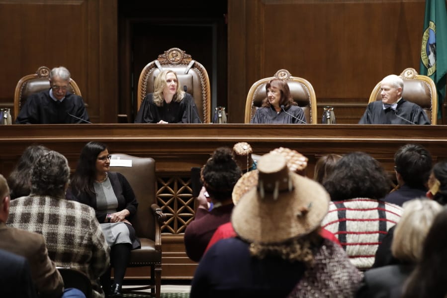 New Washington Supreme Court Chief Justice Debra Stephens, second from left, speaks from the bench after she was sworn in, Monday, Jan. 6, 2020, in Olympia. (AP Photo/Ted S.