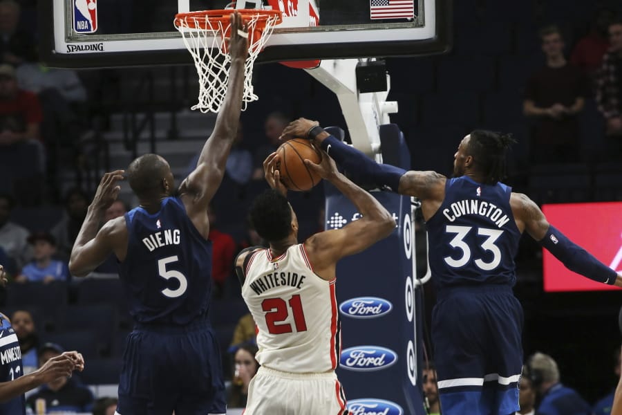 Minnesota Timberwolves&#039; Robert Covington, right, blocks a shot-attempt by Portland Trail Blazers&#039; Hassan Whiteside, center as Timberwolves&#039; Gorgui Dieng, of Senegal, also defends in the first half of an NBA basketball game Thursday, Jan. 9, 2020, in Minneapolis.