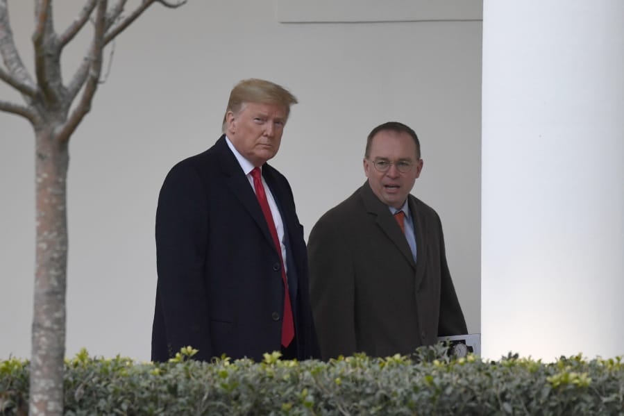 FILE - In this Jan. 13, 2020. file photo, President Donald Trump, left, and acting White House chief of staff Mick Mulvaney, right, walk along the colonnade of the White House in Washington. The federal government&#039;s watchdog agency says a White House office violated federal law in withholding security assistance to Ukraine aid. The Government Accountability Office said Thursday the White House Office of Management and Budget violated the law in holding up the assistance.