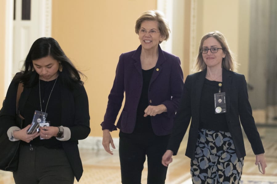 Sen. Elizabeth Warren, D-Mass., center, walks to the Senate chamber for the impeachment trial of President Donald Trump at the Capitol, Thursday, Jan. 23, 2020, in Washington.