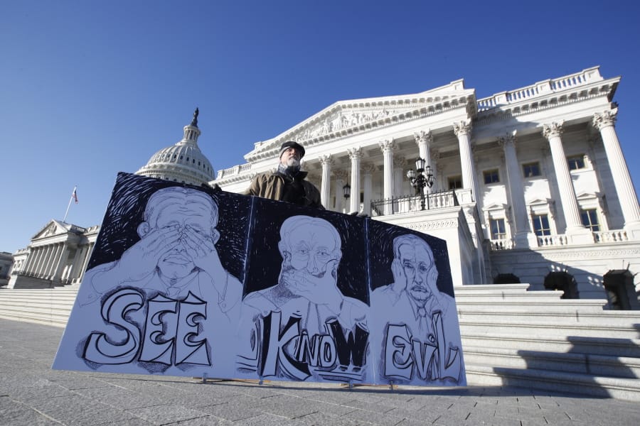 Stephen Parlato, of Bolder, Colo., displays his artwork depicting, &quot;the evil Republican senatorial judges&quot;, as he demonstrates outside the U.S. Capitol Wednesday, Jan. 22, 2020, in Washington.