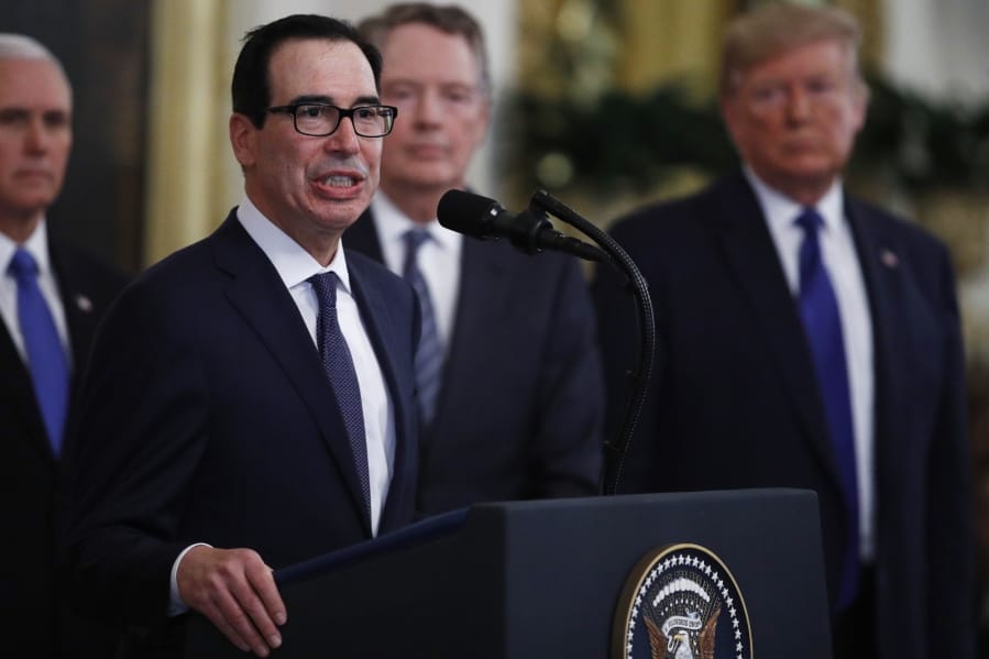 Secretary of Treasury, Steven Mnuchin, at podium, speaks as U.S. Trade Representative Robert Lighthizer, back second from right and President Donald Trump, right, listen during a signing ceremony for &quot;phase one&quot; of a US China trade agreement, in the East Room of the White House, Wednesday, Jan. 15, 2020, in Washington.