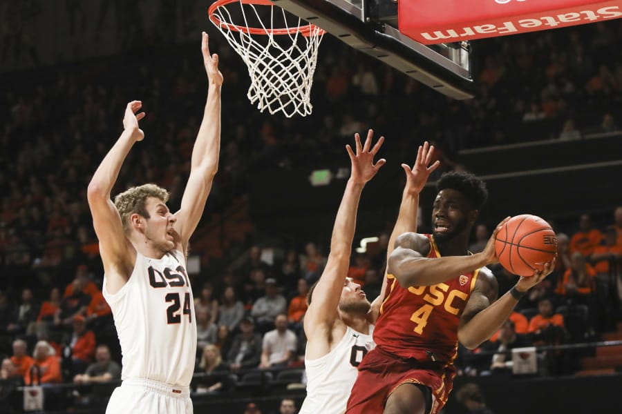 Southern California&#039;s Daniel Utomi (4) passes away from the basket to avoid Oregon State&#039;s Kylor Kelley (24) and Tres Tinkle (3) during the first half of an NCAA college basketball game in Corvallis, Ore., Saturday, Jan. 25, 2020.