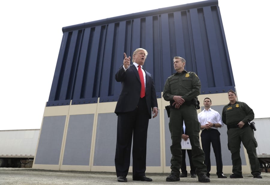 FILE - In this March 13, 2018, file photo, President Donald Trump speaks during as he reviews border wall prototypes, in San Diego, as Rodney Scott, the Border Patrol&#039;s San Diego sector chief, listens. The Trump administration has named Rodney Scott the new head of the U.S. Border Patrol. Scott will take over for Carla Provost, who is retiring, according to an announcement obtained Friday by The Associated Press from Mark Morgan, acting head of U.S. Customs and Border Protection. Scott has been a member of the Border Patrol for 27 years.