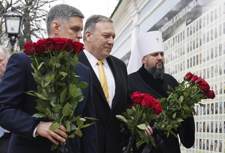 U.S. Secretary of State Mike Pompeo, center, Ukrainian Foreign Minister Vadym Prystaiko, left, and Metropolitan Epifaniy, head of the Orthodox Church of Ukraine, take part in a ceremony at the memorial to Ukrainian soldiers, who were killed in a recent conflict in the country&#039;s eastern regions, in Kyiv, Ukraine, Friday Jan. 31, 2020. U.S. Secretary of State Mike Pompeo opened a visit to Ukraine on Friday facing a delicate balancing act as he tries to boost ties with a critical ally at the heart of the impeachment trial while not providing fodder for Democrats seeking to oust President Donald Trump.