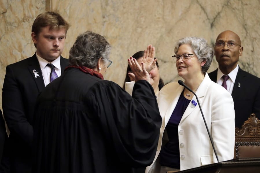 House Speaker Laurie Jinkins, D-Tacoma, second from right, is sworn in by former Washington Supreme Court Chief Justice Mary Fairhurst, second from left, Monday, Jan. 13, 2020, on the first day of the 2020 session of the Washington legislature at the Capitol in Olympia, Wash. (AP Photo/Ted S.