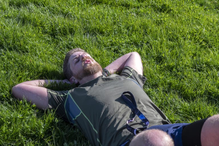 Zack Freeman of Tigard, Ore.,lies down in the grass after completing the Vancouver Lake Half Marathon.