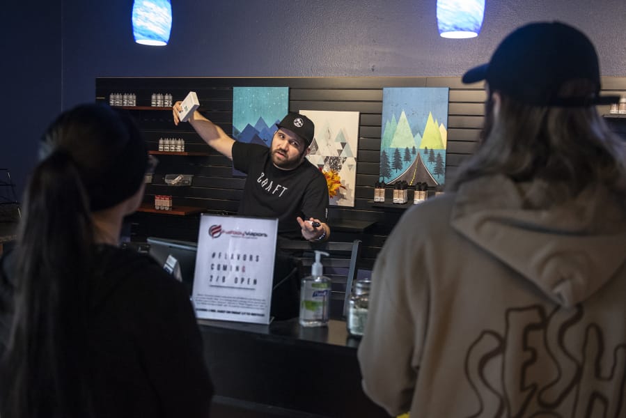 Mike Roth, manager at Fatboy Vapors on Chkalov Drive, tells customers on Friday that he will have flavored vape juice in stock today.