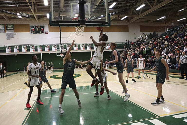 Evergreen's Cole McVay, center goes up for a shot against Peninsula in a winner-to-state game in the 3A boys basketball bi-district tournament on Saturday night, Feb. 15, 2020.