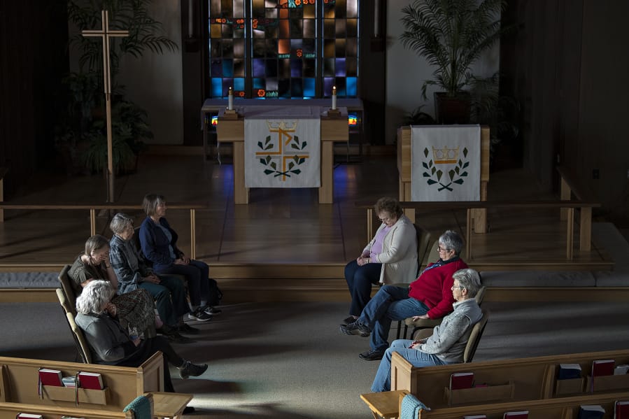 A group of women bow their heads while taking part in a 20-minute lunchtime contemplative prayer session at St.