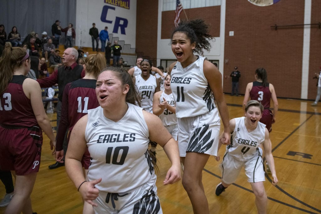 Hudson’s Bay players celebrate their victory over Prairie High School in the 3A district semifinals at Columbia River High School on Feb. 19, 2020. The Hudson’s Bay Eagles defeated the Prairie Falcons 46-45.