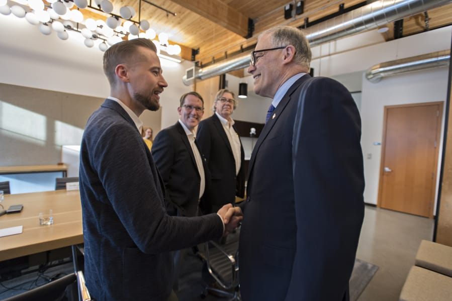 Sean McClain, founder and CEO of AbSci, left, greets Gov. Jay Inslee at the AbSci offices in downtown Vancouver on Thursday. Inslee helped the company finance a move to Vancouver in 2016, and AbSci has seen massive growth since then. Also pictured are AbSci&#039;s Johan Kers, second from left, and Fred Larimore.