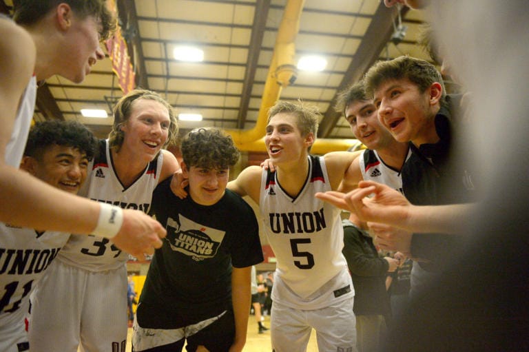 The Union boys basketball team celebrates after the 4A bi-district championship game against Battle Ground at Prairie High School on Saturday, February 22, 2020. Union beat Battle Ground 82-57.