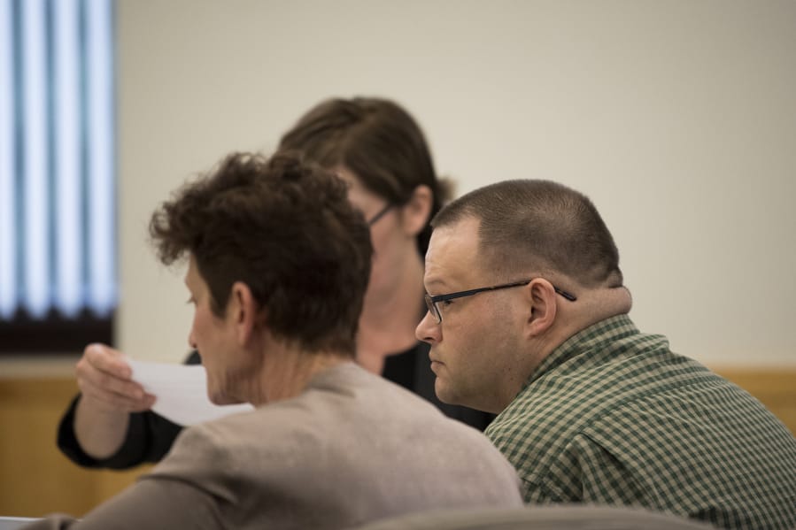 Ryan M. Burge, right, who stands accused of killing his then-girlfriend's 5-year-old daughter, Hartley Anderson, listens to opening statements in his trial in Clark County Superior Court on Tuesday afternoon, Feb. 4, 2020.