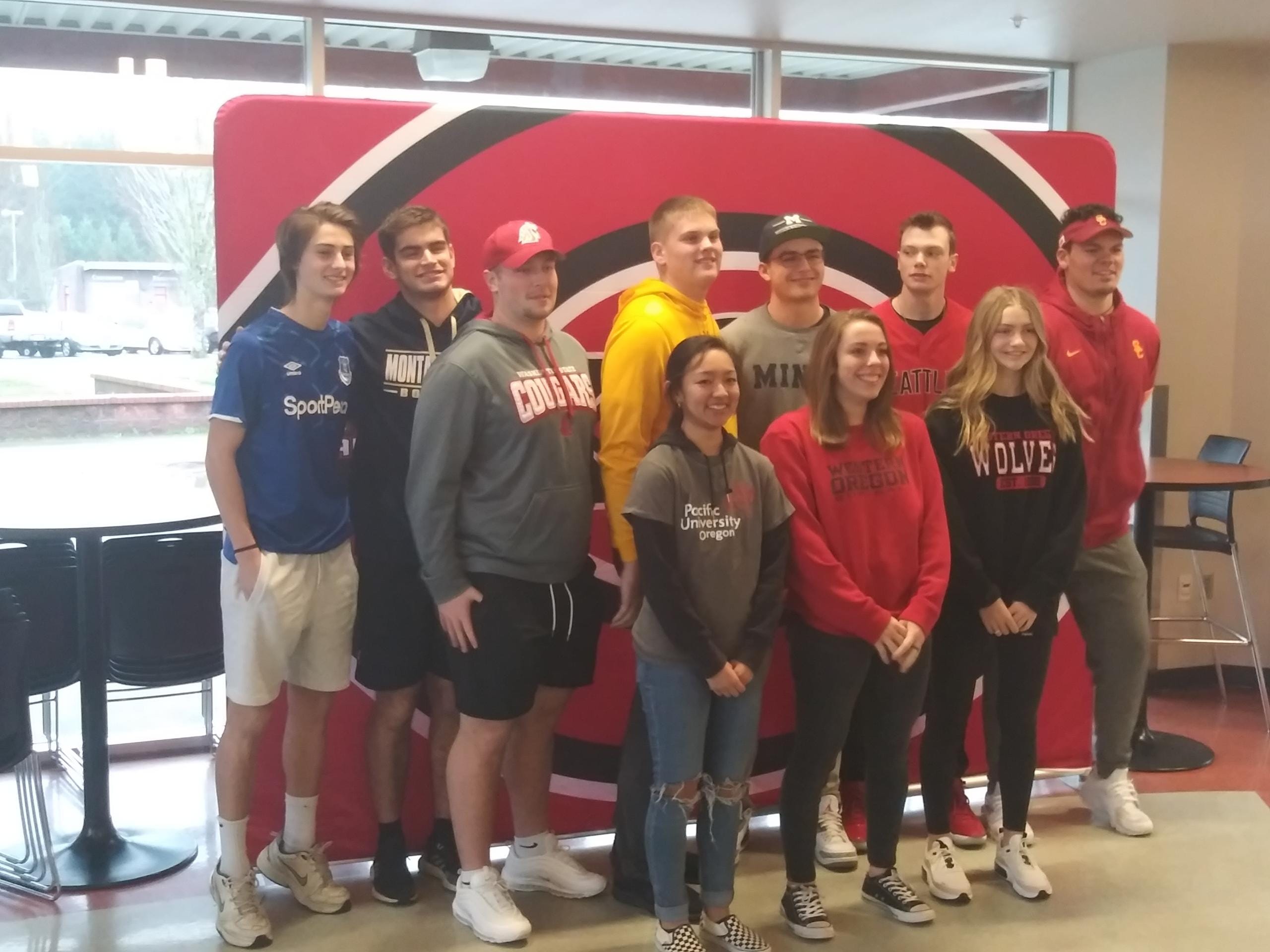 Camas students (left to right) Alexzander Samodurov, Bryce Leighton, Tristan Souza, Rush Reimer, Laurissa Tsukumura, Kenny Wright, Sophie Franklin, Riley Sinclair, Elizabeth Parker and Caadyn Stephen pose during signing day (Tim Martinez/The Columbian)