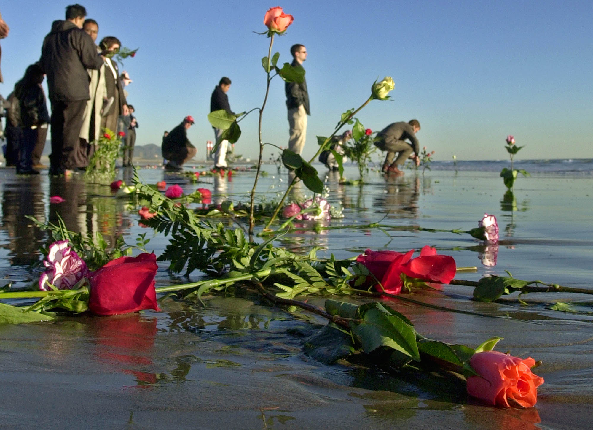 Waves lap over roses left in the surf by family members of victims after ceremonies to dedicate a monument to remember the victims of Alaska Airlines Flight 261, which plunged into the sea about eight miles offshore two years ago, at Port Hueneme Beach Park Thursday, Jan. 31, 2002, in Port Hueneme, Calif.  The crash took 88 lives when the jetliner crashed at 4:21 p.m. on Jan. 31, 2000.