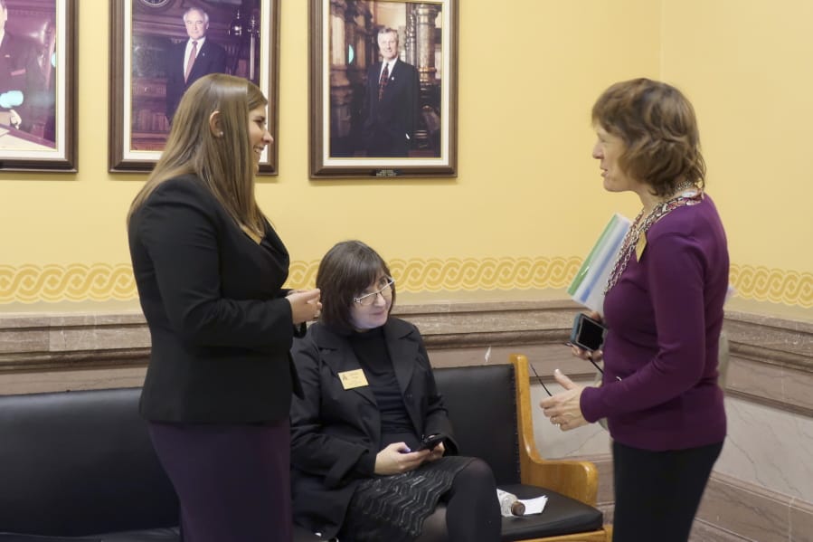 Anti-abortion lobbyists from left, Brittany Jones, of the Family Policy Alliance of Kansas; Jeannette Pryor, of the Kansas Catholic Conference, and Jeanne Gawdun, of Kansans for Life, confer outside the state Senate chamber ahead of a debate on a proposed constitutional amendment on abortion, Wednesday, Jan. 29. 2020, at the Statehouse in Topeka, Kansas. The amendment would overturn a Kansas Supreme Court decision protecting abortion rights.