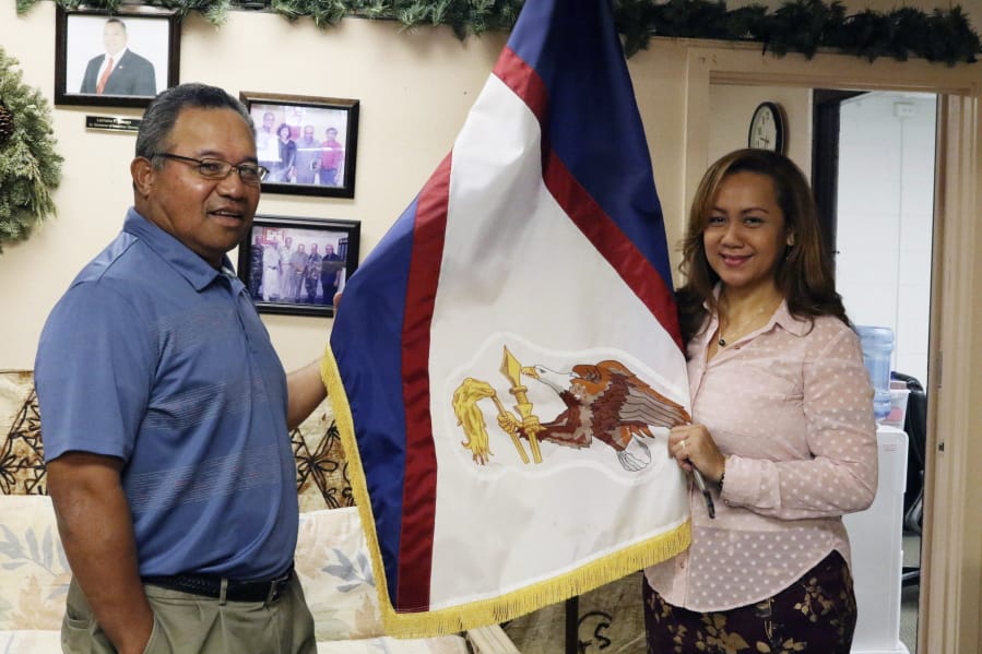 Filipo Ilaoa, left, and Bonnelley Pa&#039;uulu stand Jan. 10 with the flag of American Samoa at the American Samoa government office in Honolulu. Some American Samoans worry a federal judge&#039;s recent ruling in Utah saying those born in the U.S. territory should be recognized as U.S. citizens could threaten &quot;fa&#039;a Samoa,&quot; or the Samoan way of life.