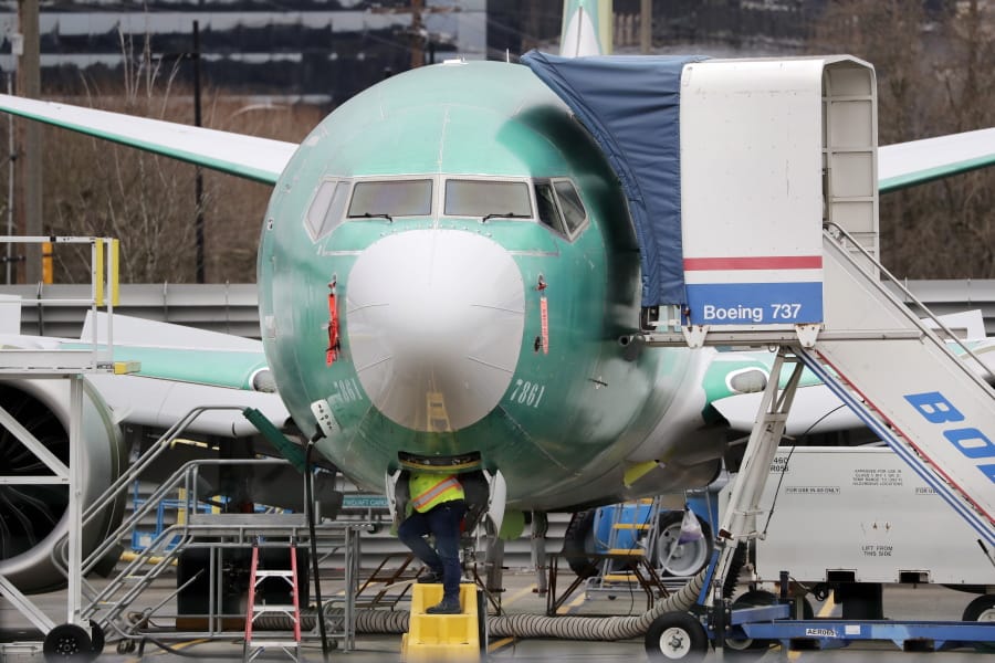 FILE - In this Dec. 16, 2019, file photo a worker looks up underneath a Boeing 737 MAX jet in Renton, Wash. Boeing sold no new airline jets in January, and now the company is worried that the virus outbreak in China could hurt airplane deliveries in the first quarter.