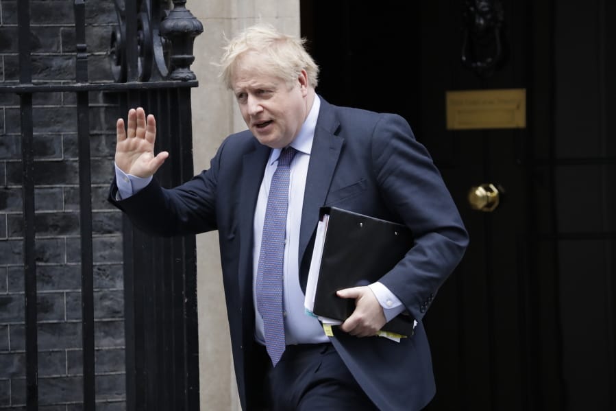 FILE - In this file photo dated Wednesday, Feb. 12, 2020, British Prime Minister Boris Johnson waves at the media as he leaves 10 Downing Street in London.  Johnson has come under pressure to dismiss adviser Andrew Sabisky, who wrote offensive comments about race and intelligence in 2014, it has been revealed Monday Feb. 17, 2020, while a Downing Street spokesman sought to distance the government from the views expressed by advisor Sabisky.