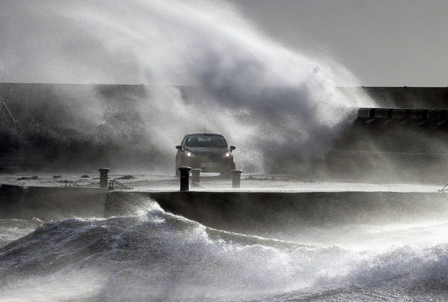 Waves lash the coast on the Ayrshire coast at Ardrossan, Scotland, Sunday, Feb. 9, 2020. Trains, flights and ferries have been cancelled and weather warnings issued across the United Kingdom and in northern Europe as the storm with winds expected to reach hurricane levels batters the region.
