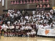 Before a bi-district basketball game Thursday, Prairie students, coaches and basketball players take a group photo to send to 20-year coach Kyle Brooks, who has been hospitalized with Guillain-Barre syndrome since Jan. 3.