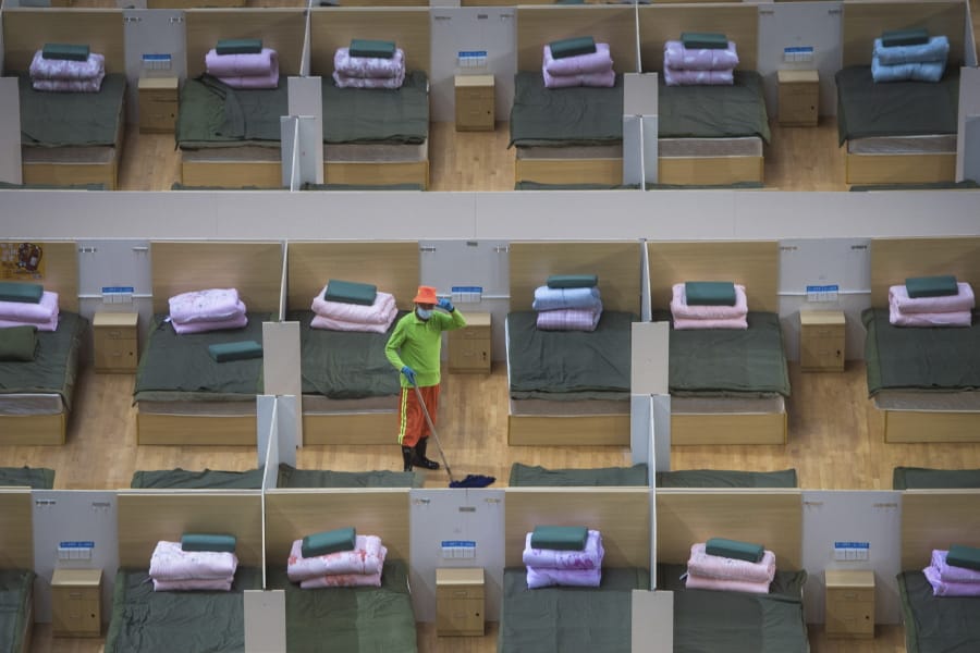 In this photo released by Xinhua News Agency, a worker cleans the floor of a temporary hospital with 1,100 beds converted from the Wuhan Sports Center in Wuhan in central China&#039;s Hubei Province, Wednesday, Feb. 12, 2020. Without enough facilities to handle the number of cases of viral infection, Wuhan has been building prefabricated hospitals and converting a gym and other large spaces to house patients and try to isolate them from others.