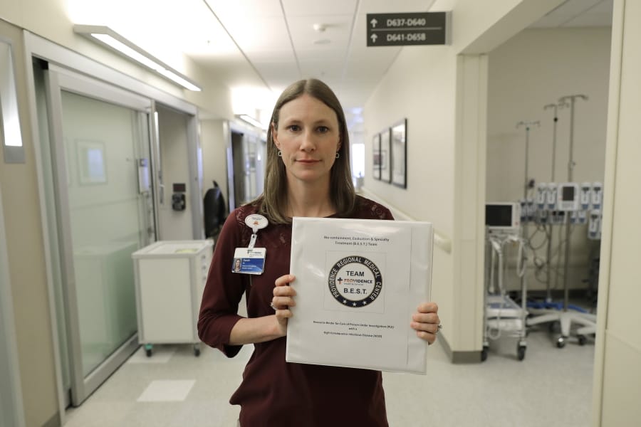 Sarah Wilkerson, manager of infection prevention at Providence Regional Medical Center in Everett, holds Jan. 23 a binder of policies for treating infectious patients. Wilkerson was part of the team that treated the first U.S. patient infected with the new virus from China. (Ted S.