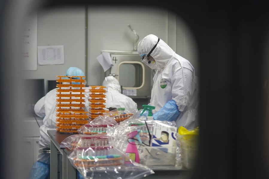Medical personnel in protective suits work Saturday at a coronavirus detection lab in Wuhan, China.