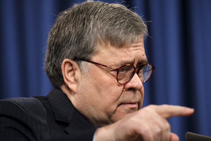 Attorney General William Barr calls on a reporter during a news conference at the Justice Department in Washington.