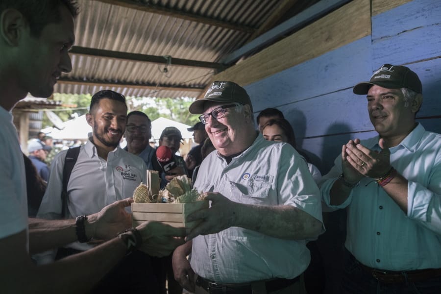 In this Jan. 29, 2020 photo, Howard Buffett receives presents during a visit, with Colombia&#039;s President Ivan Duque, right, to a cocoa farm in La Gabarra, Colombia. As a philanthropist, Buffet&#039;s priority now is helping Colombia and El Salvador, whose fight against drug trafficking has a direct impact on the U.S.