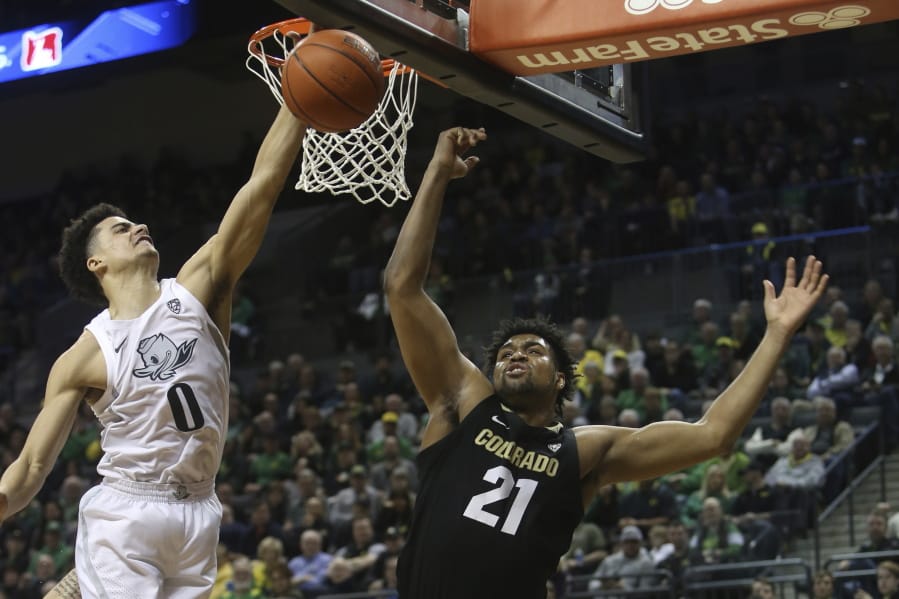 Oregon&#039;s Will Richardson, left, and Colorado&#039;s Evan Battey, center, go up for a rebound during the second half of an NCAA college basketball game in Eugene, Ore., Thursday, Feb. 13, 2020.